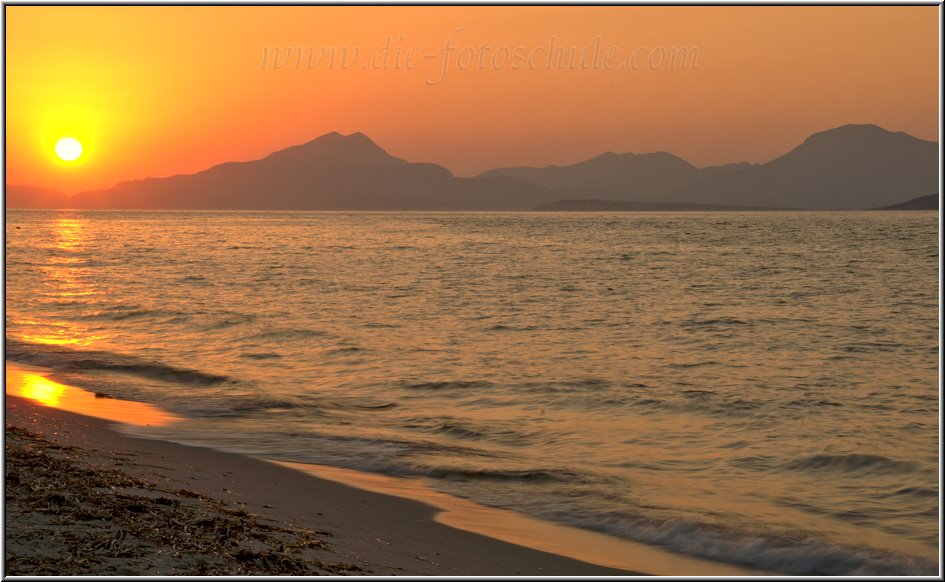 Tigaki_Tingaki_Fotoschule_003.jpg - Sonnenuntergang am Strand von Tigaki, die Sonne verschwindet hinter der Silhouette von Kalimnos