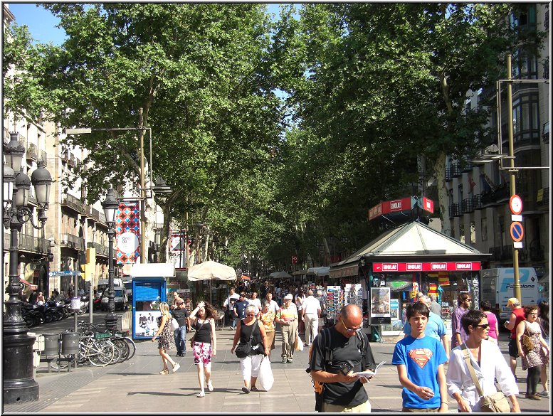 AIDA179.jpg - Die Las Ramblas ist eine 1,5 Km lange Promenade im Zentrum von Barcelona, die den Hafen mit dem Plaça de Catalunya verbindet. Sie wird zu beiden Seiten von Fahrbahnen für Autos flankiert. Manchmal flitzen Kellner über die Strassen, um die Touris an den Tischen auf der Rambla zu bedienen.