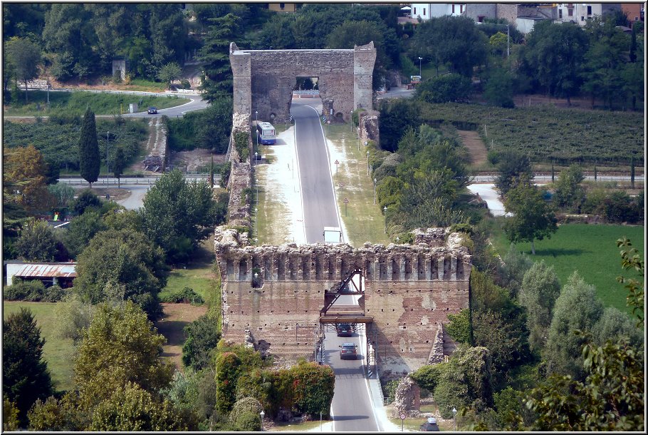 Borghetto_Valeggio_007.jpg - Valeggio, Scaliger-Kastell, Blick auf Borghetto Ponte Visconteo, eine übrig gebliebene faszinierende Ruine eines ehemaligen Damms aus Backsteinen gewaltigen Ausmaßes, die heute als Brücke über den Fluß genutzt wird. Die alten Mauern sind teils vom Grün überwuchert und der Mincio rauscht hindurch; ein faszinierendes Fotomotiv.