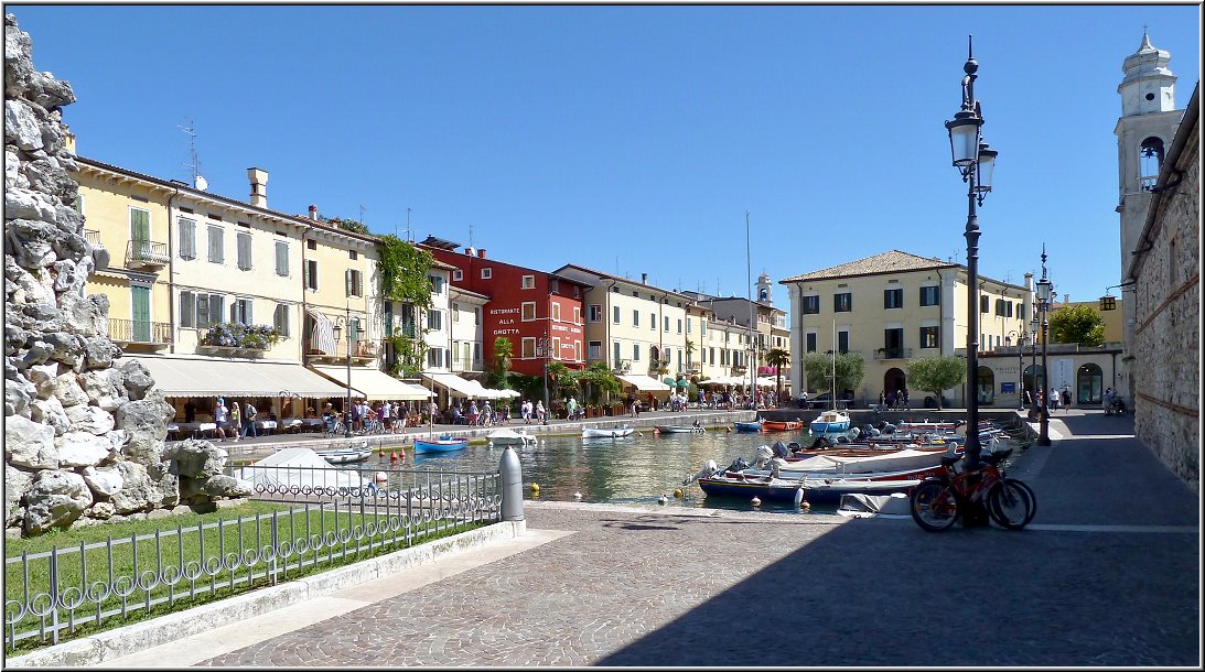 Lazise_013.jpg - La Bella Italia umrahmt von großen Mauern. Nach einer leichten Tour per Rad von Peschiera aus, gelangst Du recht fix nach Lazise mit seiner mittelalterlichen Altstadt, die von einer gut erhaltenen Stadtmauer umrahmt ist. Die Uferpromenade mit seinen gemütlichen Restaurants, Bars und Cafes zieht sich mit dem schmalen Hafenbecken tief in die engen Gässchen und kleinen Plätze der Altstadt hinein.