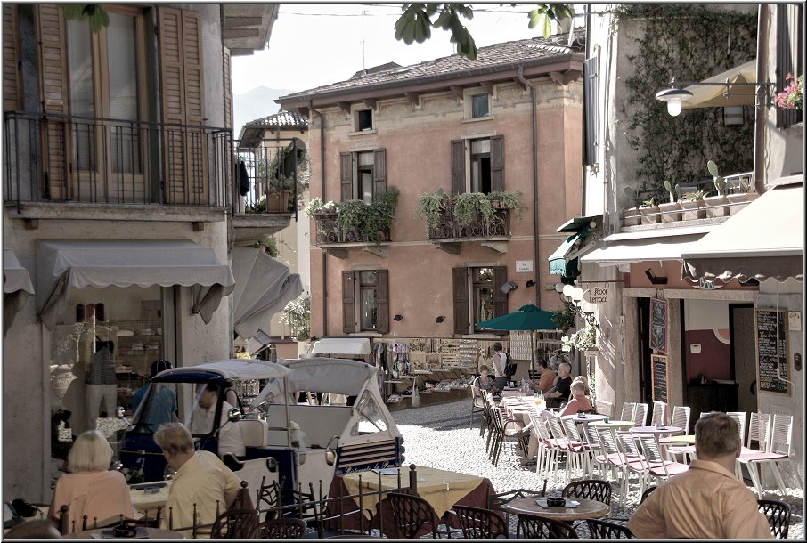 Malcesine_030.jpg - Malcesine ist die größte Stadt am Ostufer, nördlich von Garda. Neben Bardolino ist Malcesine die beliebteste Stadt der Deutschen am Gardasee, was man auch deutlich merkt. Aus dem allgegenwärtigen Gemurmel hört man in der Tat überwiegend deutsche Wortfetzen. Malcesine ist umrahmt von Bergen, das ist ein ganz anderes Bild, als ich es gewohnt bin von Lazise oder Peschiera. In fast jeder Gasse schimmert irgendwo im Hintergrund ein Bergmassiv.