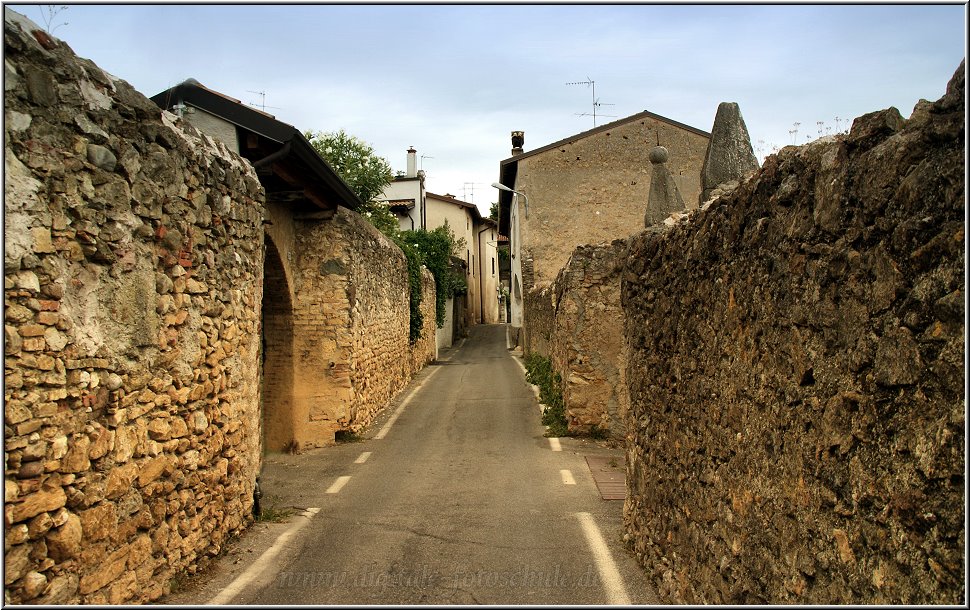 Manerba_001.jpg - Einen wunderschönen Blick über den Süden des Gardasees auf Sirmione, Garda, Bardolino, Lazise und Peschiera genießt man von der Rocca di Manerba, einer Burgruine auf einem steilen markanten Felsen bei Montinelle. Montinelle ist eines von acht Dörfer, das inmitten von Weingärten und Olivenhainen des Valtenesis die Gemeinde Manerba bilden. Man kann unterhalb des kleinen alten Ortes parken und dann zum Aussichtspunkt aufsteigen. Das kann ich nur jedem empfehlen, denn die Sicht ist einfach grandios.