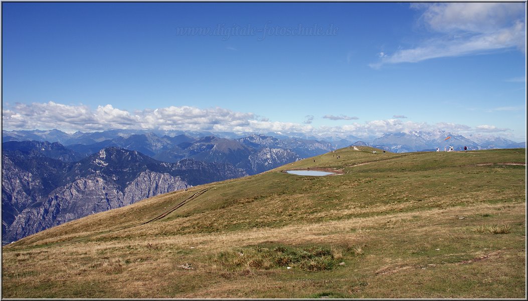 MonteBaldo_004.jpg - Du kannst von der Bergstation aus herrlich über den Kamm wandern und unentwegt aussergewöhnliche Ausblicke geniessen. Was mich, als Strandurlauber, ganz besonders faszinierte waren diese unglaublichen Perspektiven durch die immense Höhe. Und noch etwas fiel mir zwei Tage nach meinem Venedig- Besuch besonders auf: die Ruhe hier. Steile Wiesen laden zum Pausieren ein, da sitzt Du schön im Windschatten und kannst den Blick auf den See geniessen; ohne irgendwas zu hören. Es ist total still. Also noch nichtmal ein Meer, das rauscht. So eine komplette Stille ist für mich eine echte Erfahrung, die ich noch nicht kannte. Wer weiß, vielleicht werde ich noch ein echter Bergfan. Zumindest war ich froh, an meinen Polfilter gedacht zu haben, denn beim Blick auf den See bekommt der Ausdruck Blaustich eine echte Gestalt. Selbst der UV- Filter zeigte erstmals einen Effekt, denn bisher kam mir der Filter immer nur als reines Fensterglas vor.