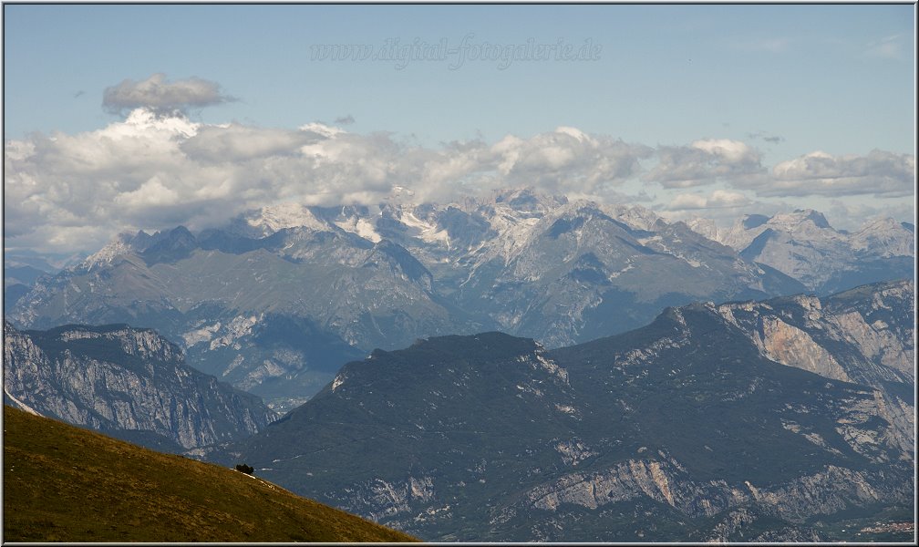 MonteBaldo_007.jpg - Und wie bereits erwähnt, Malcesine bringt Dich auf Wunsch ganz hoch hinaus:Von Malcesine fährt die Funivia Seilbahn zur 1760 Meter hoch gelegenen Bergstation auf einen Gipfel des Monte Baldos. Wenn Du das vorhast, solltest Du allerdings recht früh an der Talstation stehen, denn bei guter Fernsicht bildet sich hier auch in der Nebensaison eine meterlange Schlange (Wartezeit im Schnitt eine gute Stunde). Die Fahrt führt über eine Mittelstation, in der Du die Gondel wechselst (also aussteigen und einsteigen) steil hinauf. Der Ausblick schon in der Gondel ist grandios und einzigartig. Die obere Gondel nach der Mittelstation dreht sich während der Fahrt um 360 Grad. Ergatterst Du einen Fensterplatz, kannst Du das Panorama auf jeden Fall voll geniessen. Die oberen Gondeln (es sind zwei, eine hoch, eine runter) werden übrigens mit 77 Passagieren gefüllt, bevor es losgeht (nix für Leute, die den Atem des Nachbarn nicht mögen...). Unter der Talstation liegt ein Parkhaus, das Du über einen Kreisverkehr (wie sollte es auch anders sein) direkt von der Gardesana aus erreichen kannst. Die Parkgebühr beträgt für Seilbahnfahrer 4,50 EUR pro Tag, eine Fahrt hoch und runter mit der Seilbahn 18,-- EUR. Mountainbike-Fans können ihr Rad zu bestimmten Zeiten mitnehmen (gegen Gebühr), auch Paraglider müssen auf ihre Ausrüstung nicht verzichten.