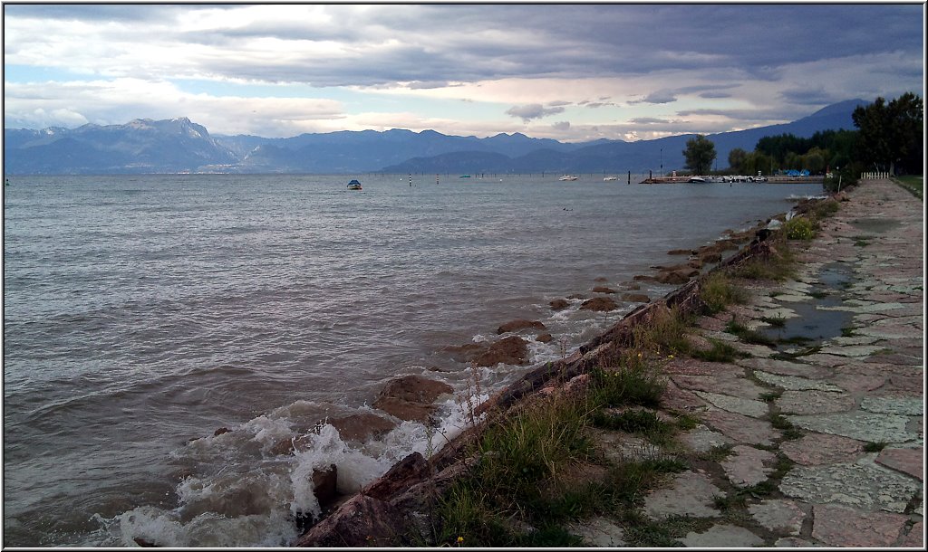 Peschiera_012.jpg - Der typische Strand an den Campingplätzen in Richtung Lazise. Dieses Bild enstand am späten Nachmittag eines Regentages. Bei schönem Wetter stapeln sich hier die Sonnenhungrigen.