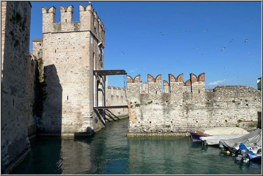 Sirmione_004.jpg - Sirmione ist ganz sicher das i-Tüpfelchen des südlichen Seeufers.Ein breiter Wassergraben trennt die schöne Altstadt vom Festland, das hier schmal und lang gute vier Kilometer in den Gardasee ragt. Das gibt es an keiner anderen Stelle des Gardasee´s. Als jahrzehntelanger Italienfan kann ich nur sagen: die romantisch verwinkelte und besonders am Abend recht bunte Altstadt macht Italienträume wahr. Neben der einzigen Brücke steht die wunderschöne Wasserburg und weiter nördlich lädt die parkartig angelegte Inselspitze zu einem entspannenden Spaziergang mit einzigartigem Seeblick ein.