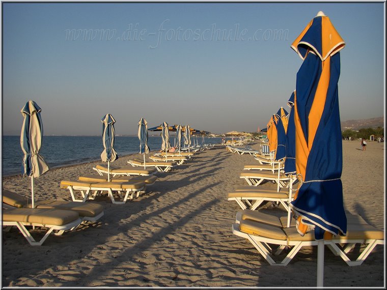 Tigaki_Tingaki_Fotoschule_040.jpg - Strandliegen am Strand von Tigaki.  Kilometerweit reihen sie sich nebeneinander auf.